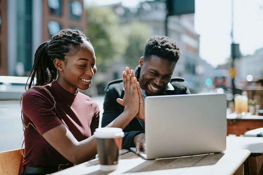 a man and lady high five after learning they will earn interest on their checking account.